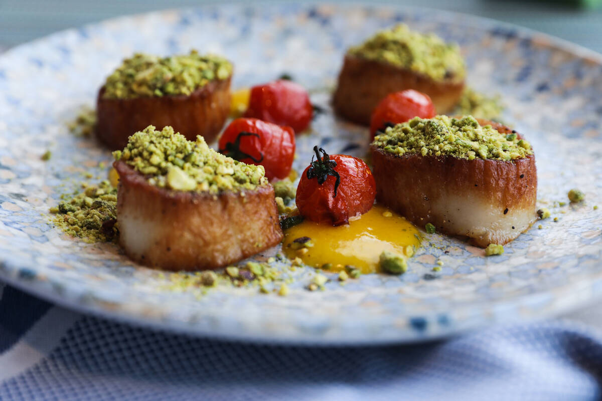 Seared scallops with saffron cream, prosecco sauce, cherry tomatoes, and pistachio at Lago, a f ...