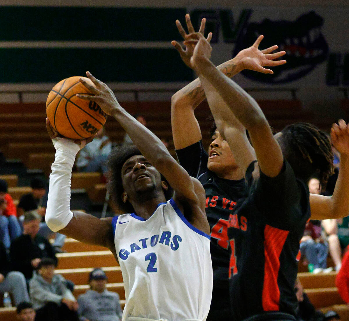Green Valley's Scott Hammond (2) tries to shoot as Las Vegas' Marcus Gomez (4), center, and Las ...