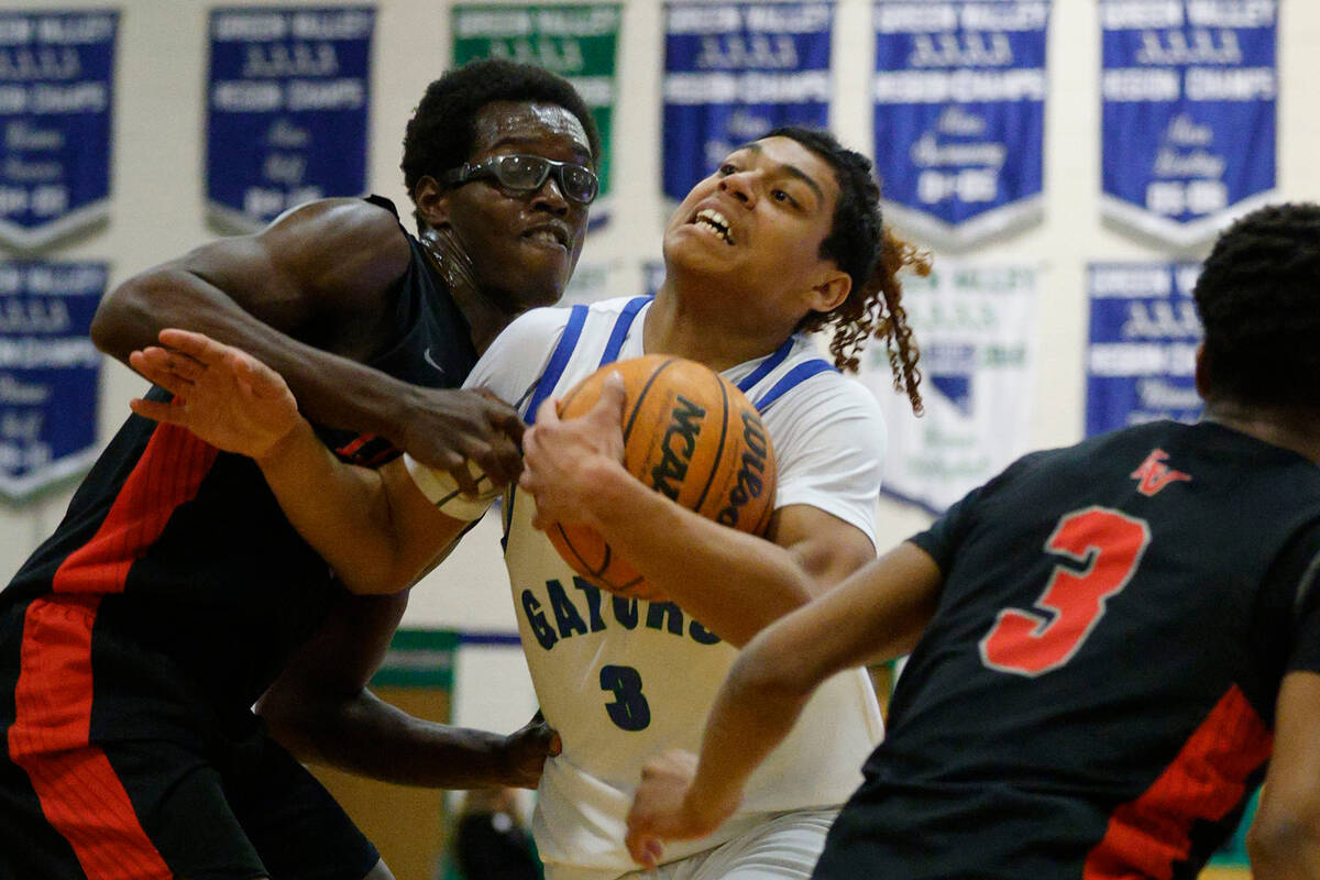 Green Valley's Gaston Zumaya (3) tries to drive past Las Vegas' Jordan Stevens (24), left, and ...