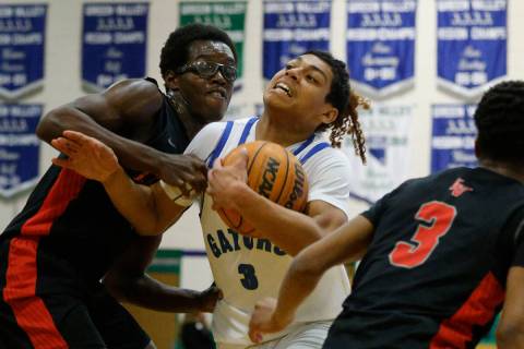 Green Valley's Gaston Zumaya (3) tries to drive past Las Vegas' Jordan Stevens (24), left, and ...