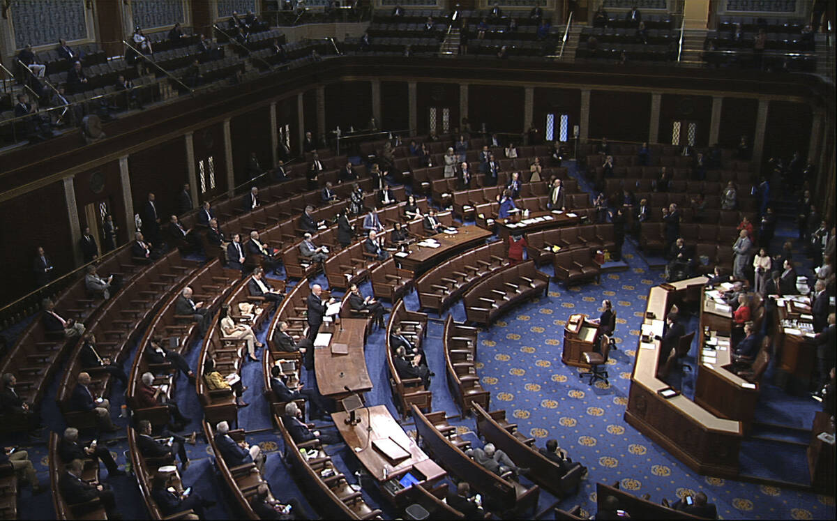 FILE - In this image from video, members of the House practice social distancing as they sit on ...