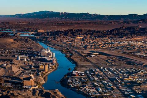 Morning lights the downtown Laughlin, Nev., waterfront, left, and Bullhead City, Ariz., along t ...