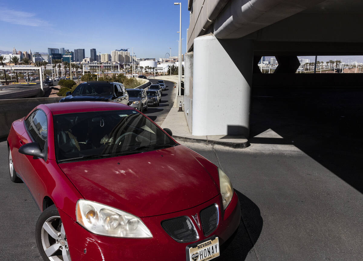 Passengers line up to enter the level 2 of Terminal 1 parking lot at Harry Reid international A ...