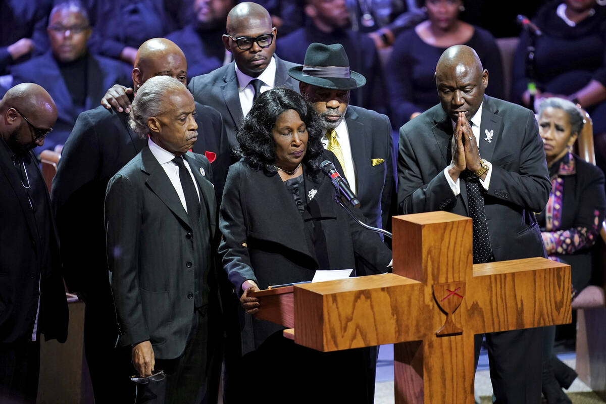 Flanked by Rev. Al Sharpton, left, her husband Rodney Wells, second from right, and attorney Be ...