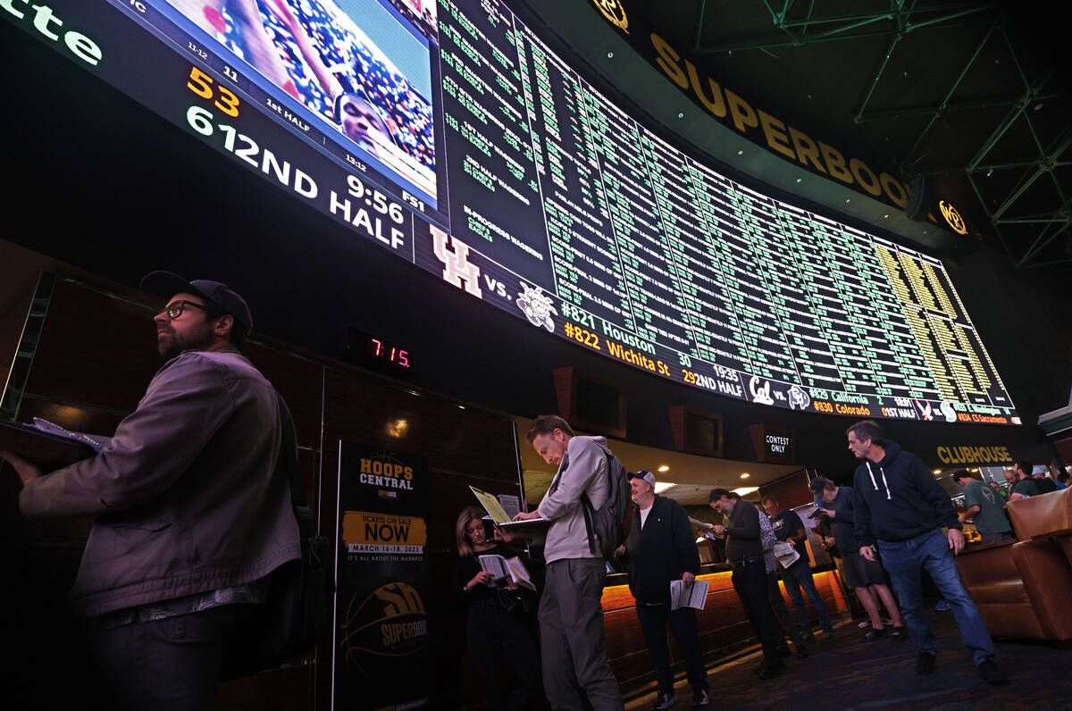 Sports bettors line up as the menu of Super Bowl props is on display at the Westgate SuperBook, ...