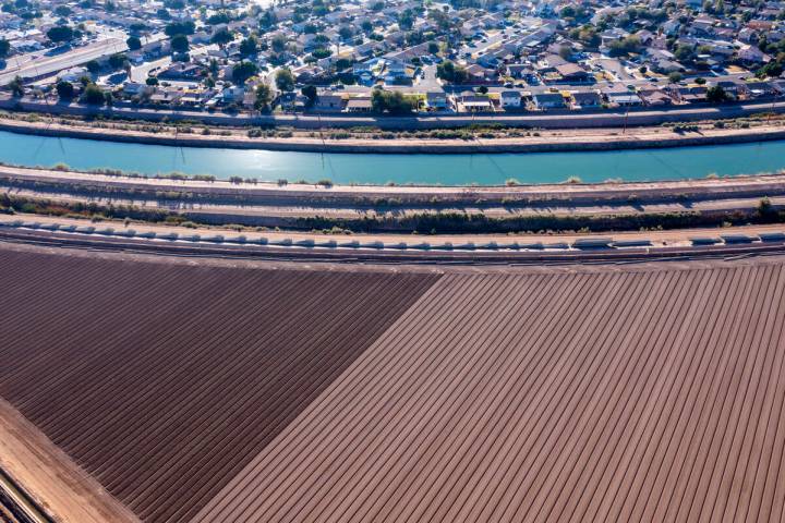 The All-American Canal runs between growing fields and a residential development in Calexico. ( ...