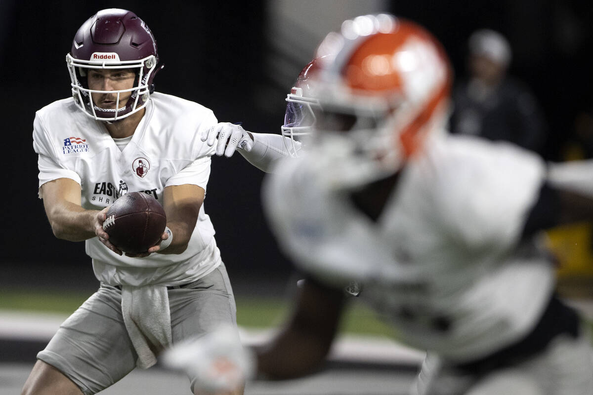 East quarterback Tim DeMorat of Fordham, left, passes the ball off to the running back during t ...