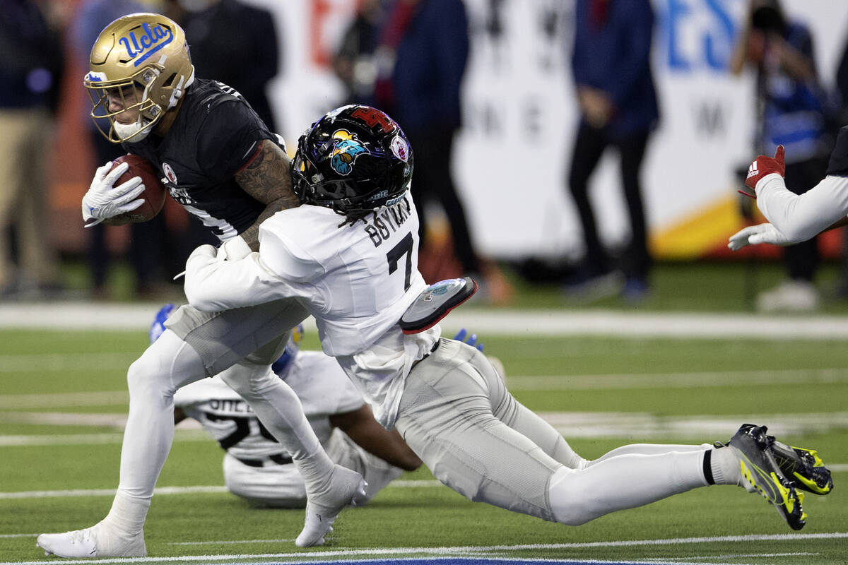 West running back Kazmeir Allen of UCLA, left, is sacked by East cornerback Lance Boykin of Coa ...