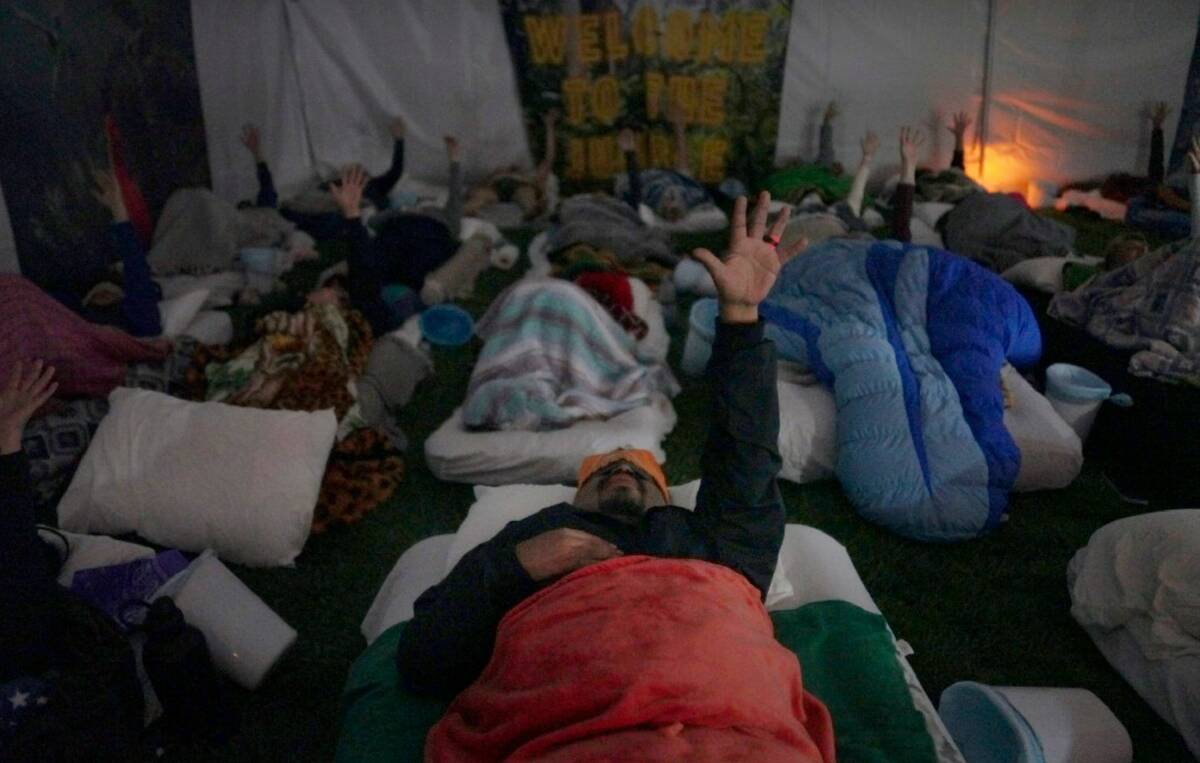 Lorenzo Gonzales, center, and other retreat participants reach their hands to the sky during a ...