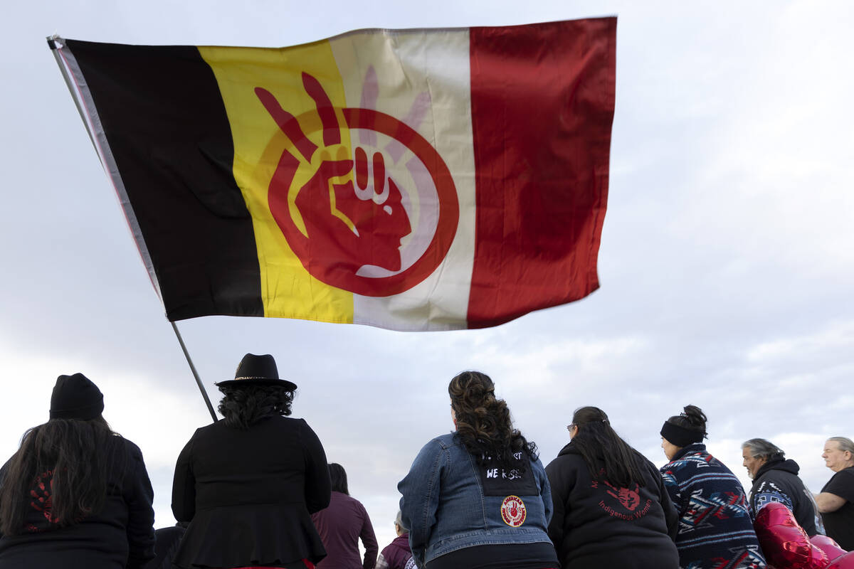 A group with the American Indian Movement flies their flag during a memorial for Anna Scott, a ...
