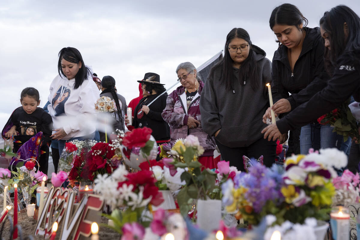 Loved ones of Anna Scott, a member of the Pyramid Lake Paiute Tribe, place candles on her grave ...