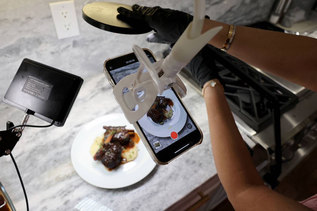 TikTok star Genevieve LaMonaca adjusts the light while showing her recipe for short ribs at her ...