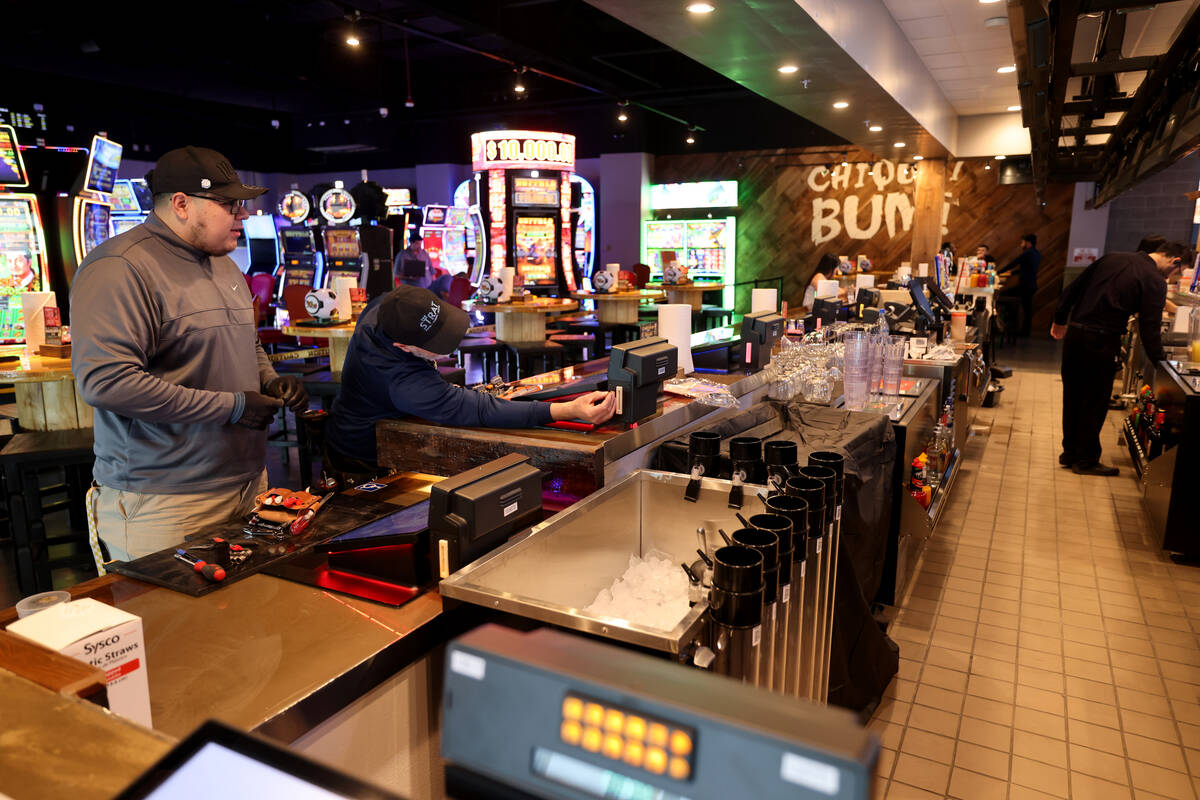 Workers install bar top gaming machines at the new Ojos Locos Sports Cantina y Casino on Civic ...