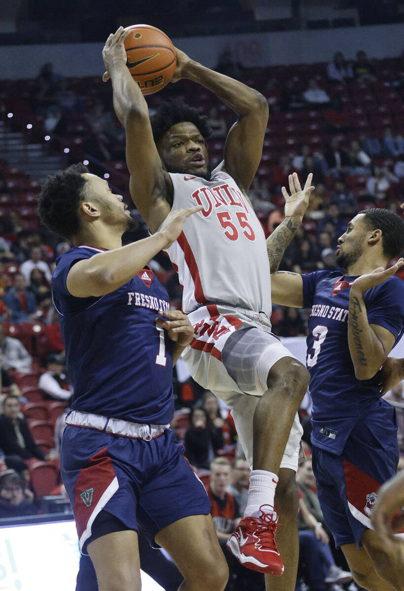 UNLV Rebels guard EJ Harkless (55) shoots over Fresno State Bulldogs guard Jemarl Baker (1) and ...