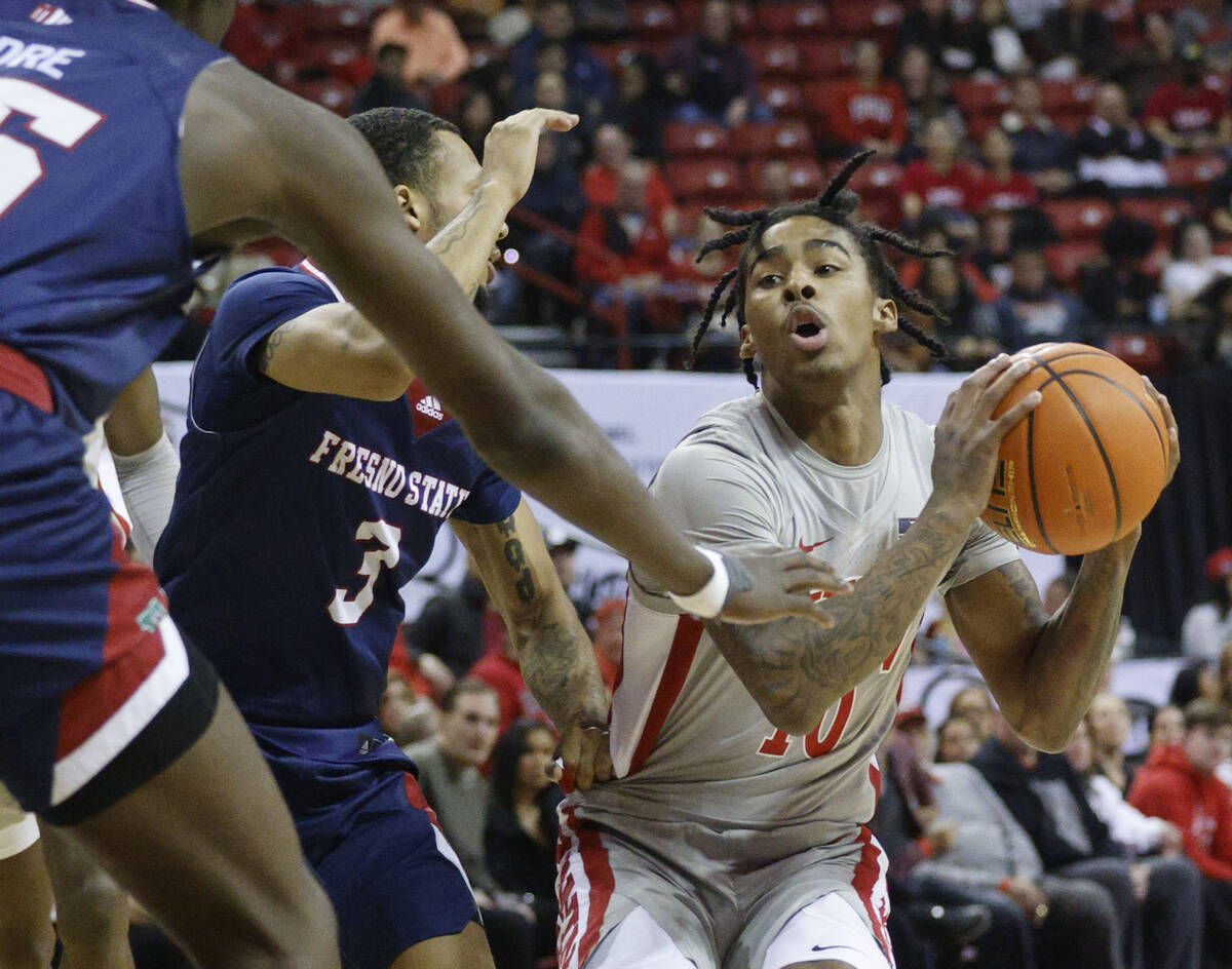 UNLV Rebels guard Keshon Gilbert (10) looks to pass against Fresno State Bulldogs guard Isaiah ...