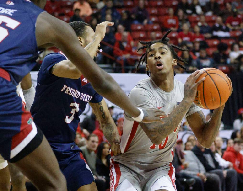 UNLV Rebels guard Keshon Gilbert (10) looks to pass against Fresno State Bulldogs guard Isaiah ...