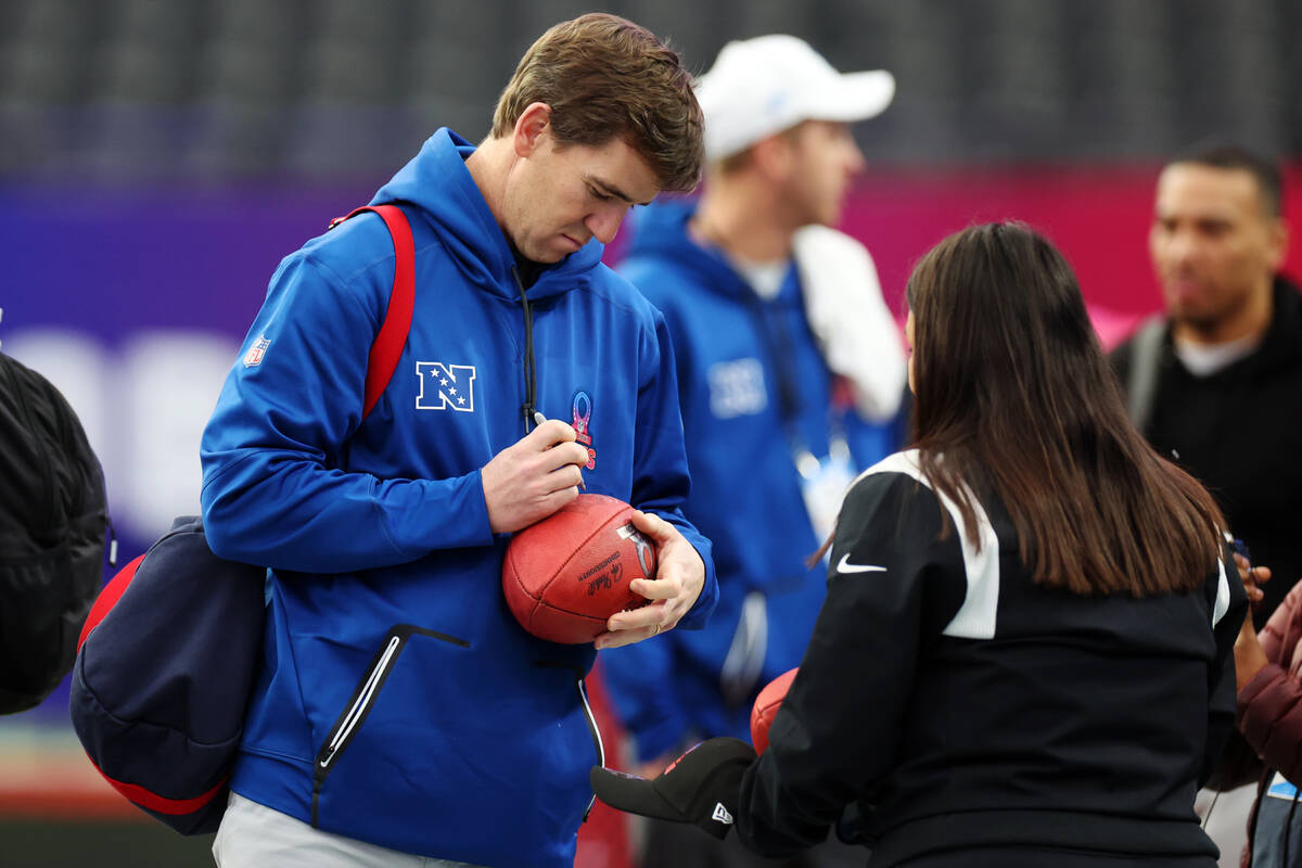 Retired NFL quarterback Eli Manning signs an autograph during a Pro Bowl rehearsal event at All ...