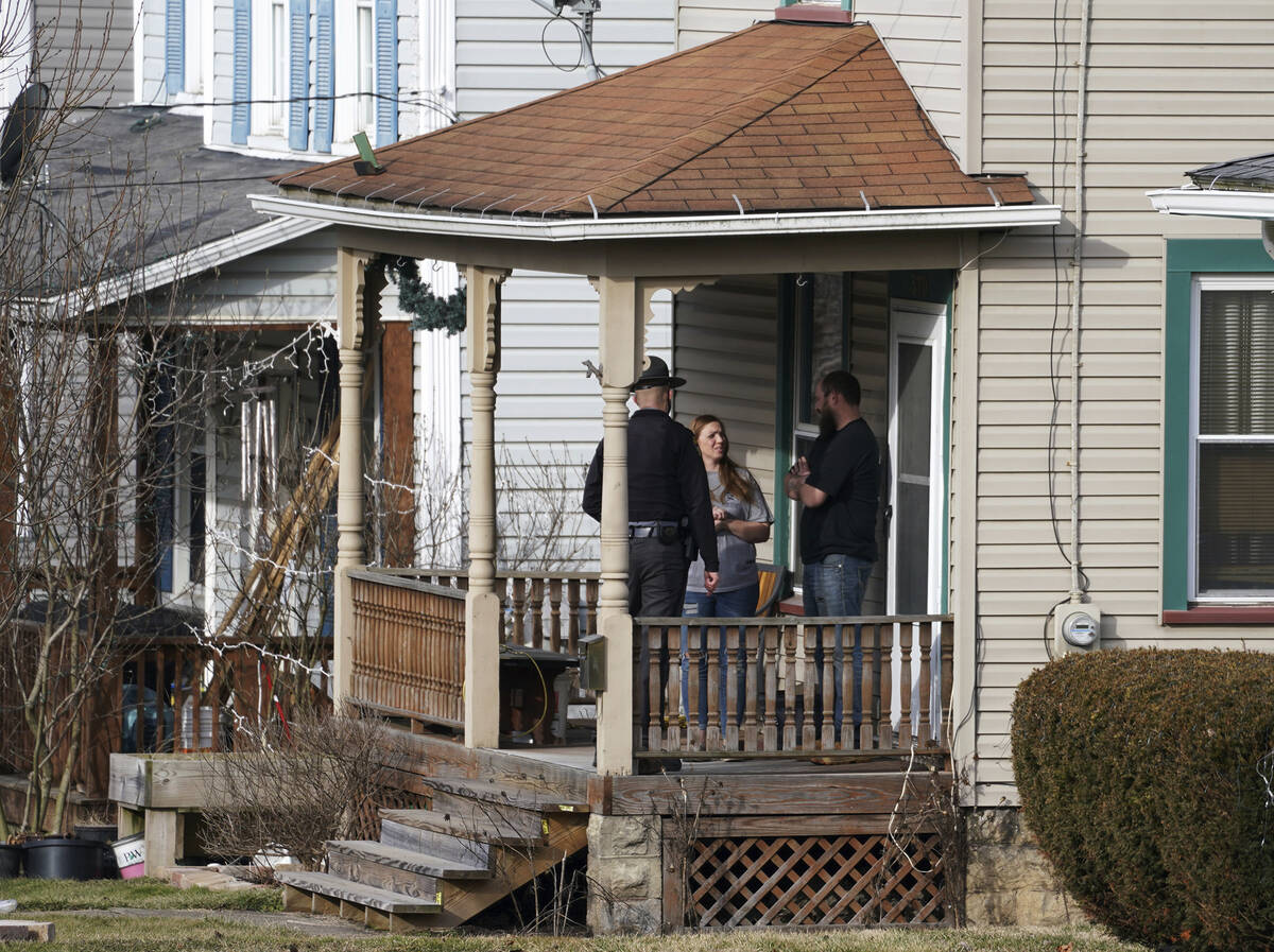An Ohio state trooper goes door to door telling residents to leave downtown East Palestine, Ohi ...