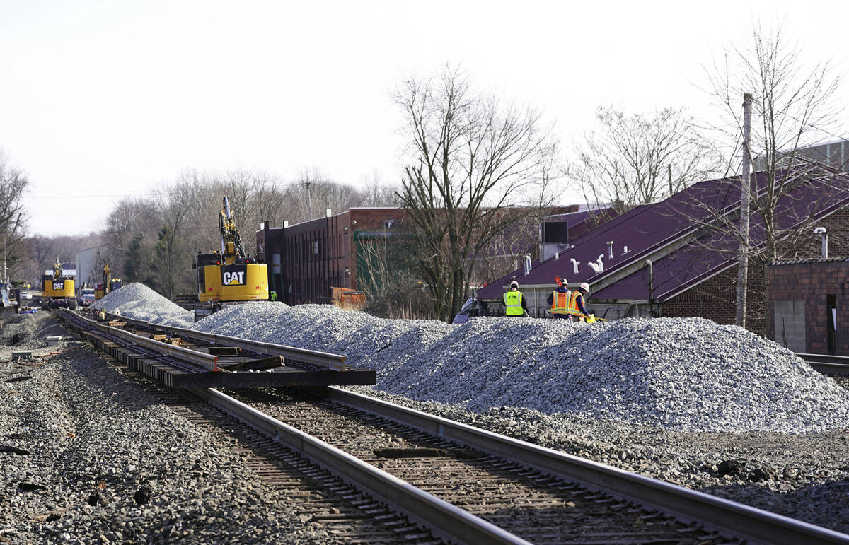 Equipment and gravel pile up along the railroad tracks in downtown East Palestine, Ohio, on Sun ...