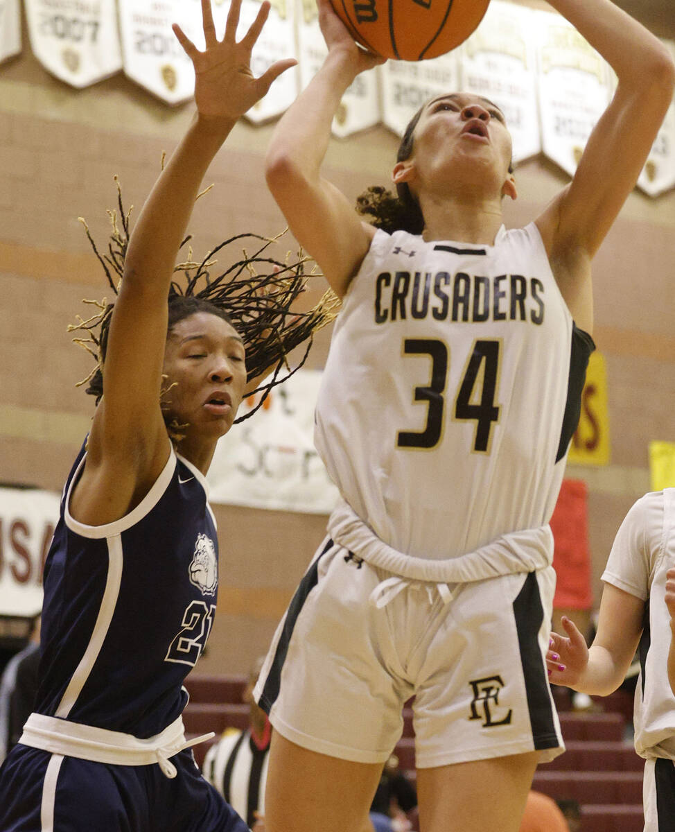Faith Lutheran's Leah Mitchell (34) shoots the ball as Centennial's Cici Ajomale (21) tries to ...