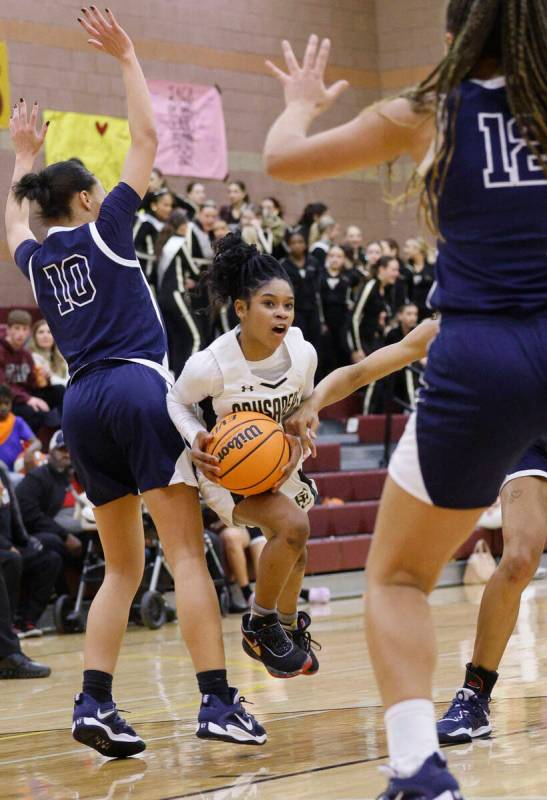 Faith Lutheran's Tamiah Harrison (4) tries to drive past Centennial's Tayla Perkins (10) and Ce ...