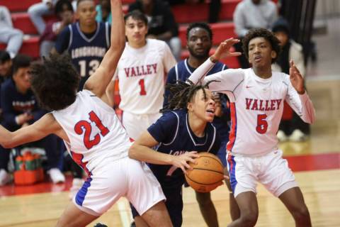 Legacy's guard Ja'Merion Brass (11) moves the ball between Valley's Kevan Wilkins (21) and Stev ...