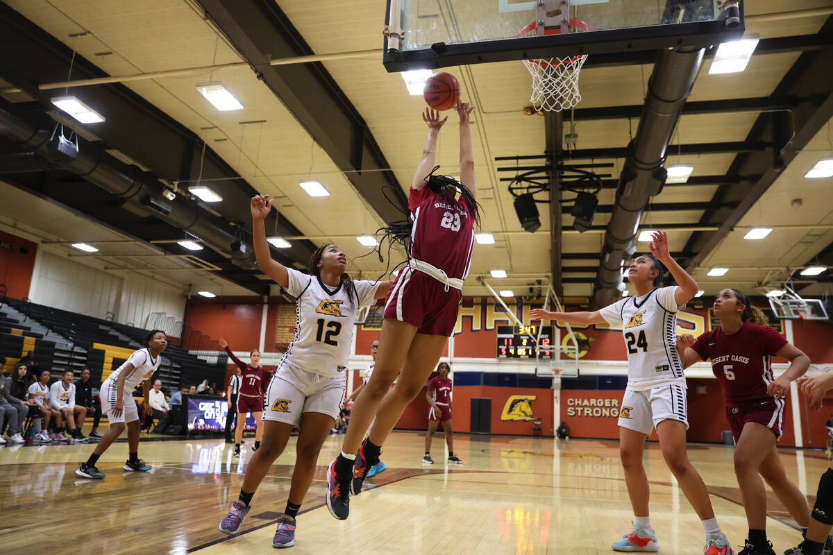 Desert Oasis' Madison Pescado (23) goes up for a shot as Clark's Paradise Norsworthy (12) and T ...