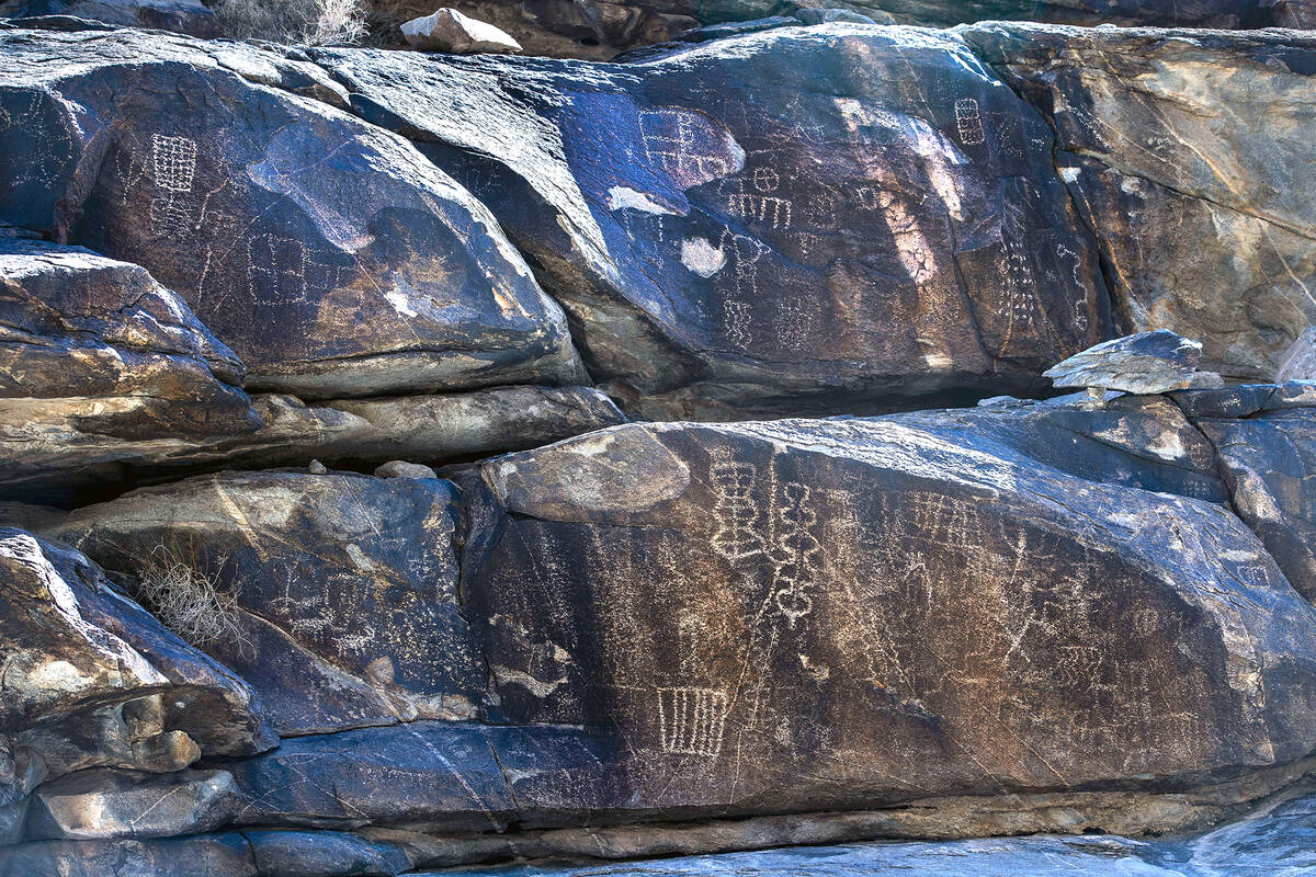 Native American petroglyphs line the rock walls along the canyon bottom in Hiko Springs. (L.E. ...