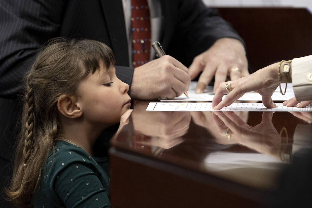 Ollie, a guest of Assemblyman Ken Gray, R-Dayton, watches as he signs his oath of office during ...