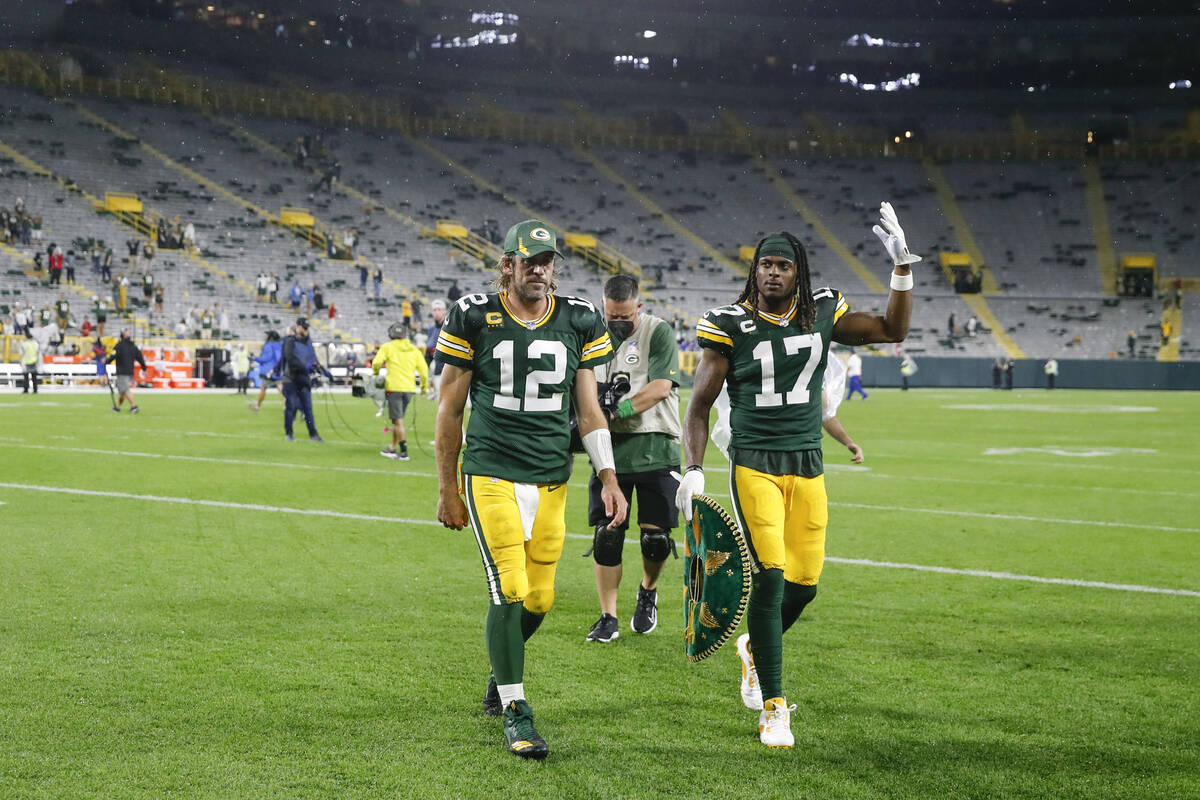 Green Bay Packers quarterback Aaron Rodgers (12) and wide receiver Davante Adams (17) walk off ...