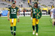 Green Bay Packers quarterback Aaron Rodgers (12) and wide receiver Davante Adams (17) walk off ...