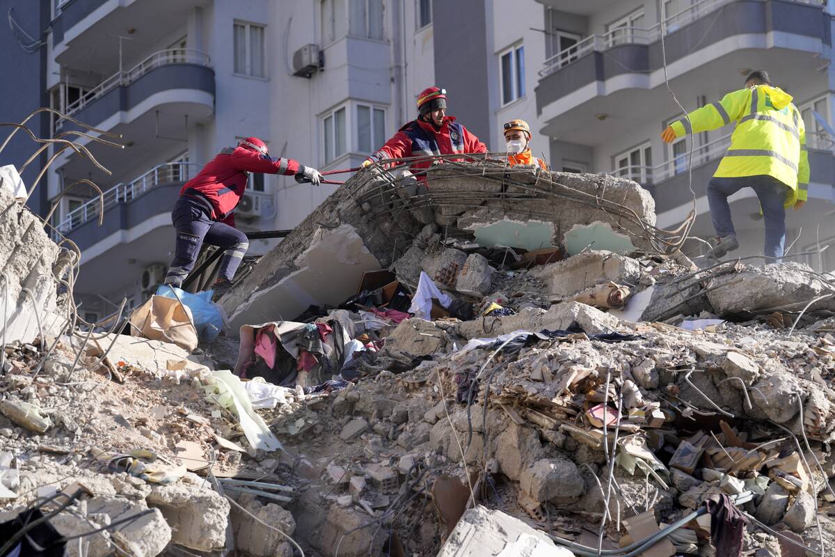 Emergency teams search for people in the rubble in a destroyed building in Adana, southern Turk ...