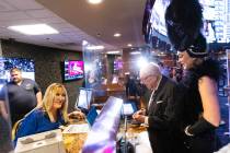 Oscar Goodman, former Las Vegas mayor, accompanied by showgirl Kristina Schiavi, places his ann ...