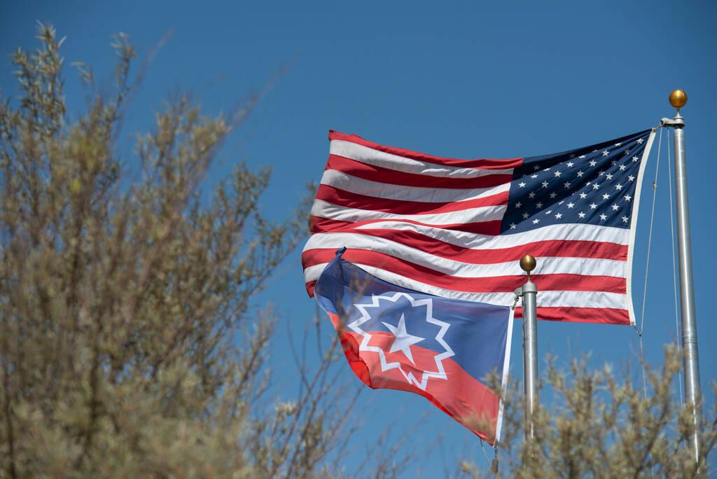 The American flag and the Juneteenth flag blow in the high winds outside the North Las Vegas Ci ...