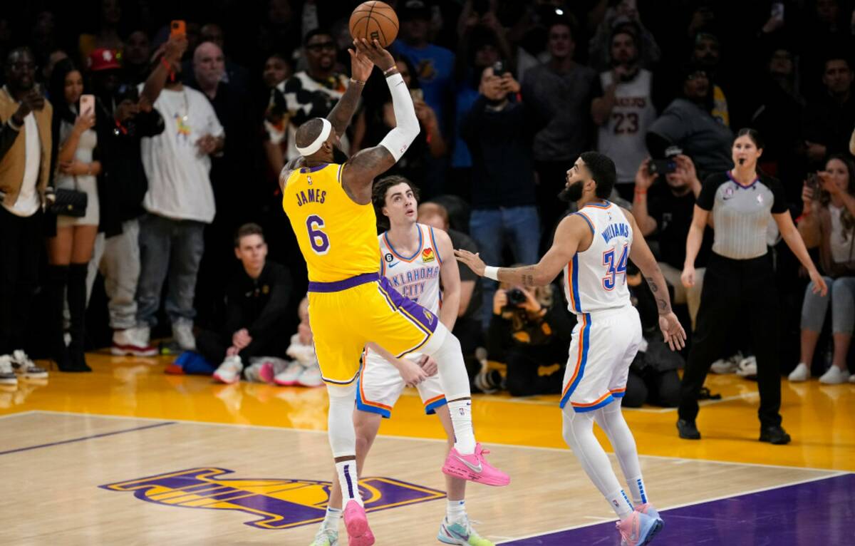 Los Angeles Lakers forward LeBron James, left, scores to pass Kareem Abdul-Jabbar to become the ...