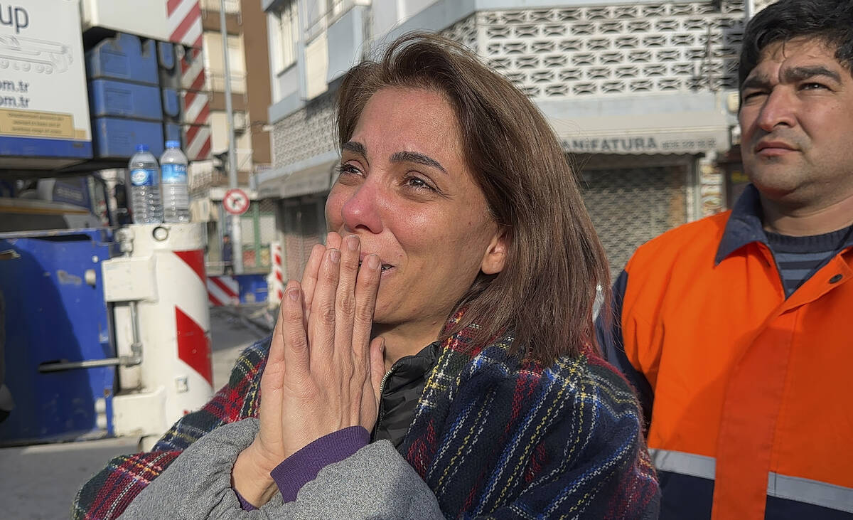 A woman reacts while watching rescue works in Iskenderun, southern Turkey, Wednesday, Feb. 8, 2 ...