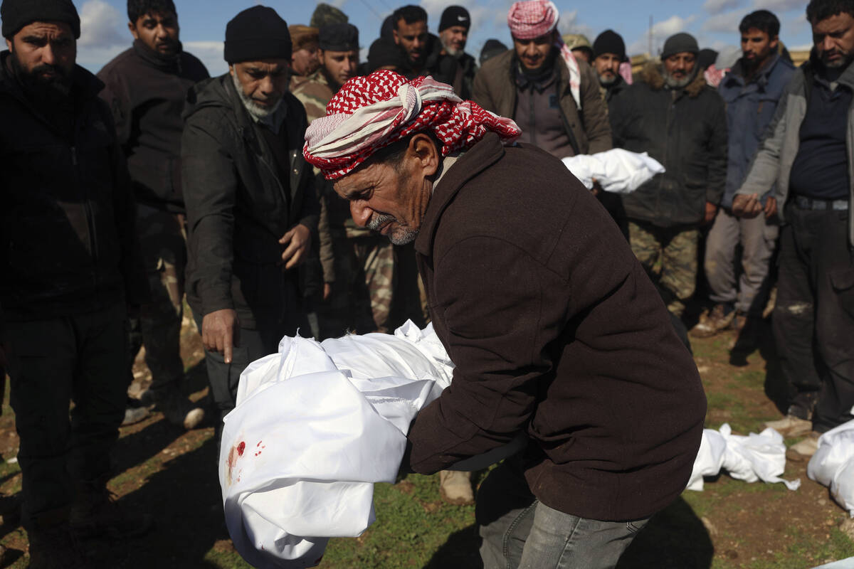 Mourners bury family members who died in a devastating earthquake that rocked Syria and Turkey ...