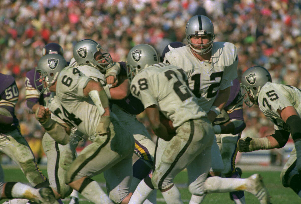 Oakland Raiders' quarterback Ken Stabler hands off the ball to teammate Clarence Davis during f ...