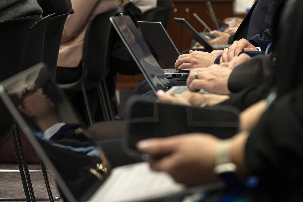 Attendees of a meeting of the Senate Committee on Education use their devices during the 82nd S ...
