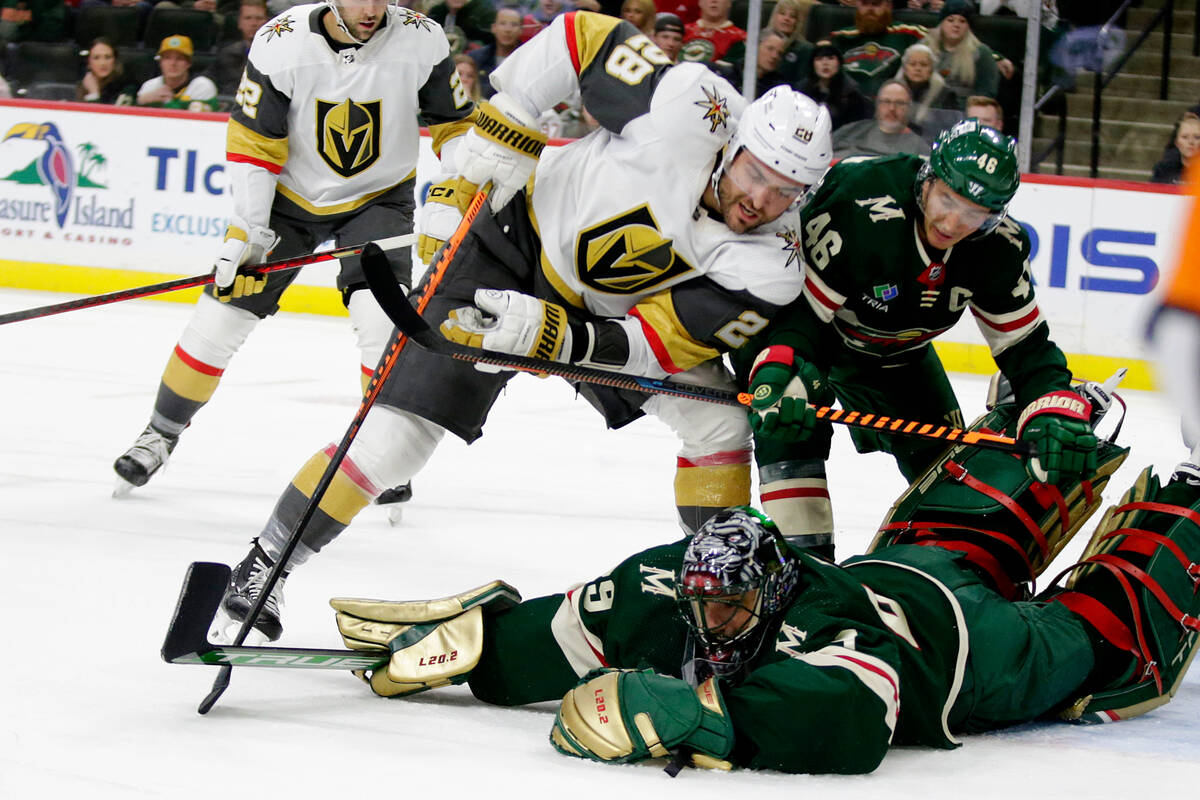 Minnesota Wild goaltender Marc-Andre Fleury (29) dives on the puck with Vegas Golden Knights le ...