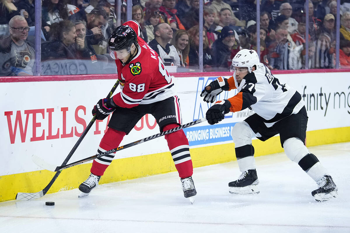 Chicago Blackhawks' Patrick Kane, left, tries to keep the puck away from Philadelphia Flyers' T ...