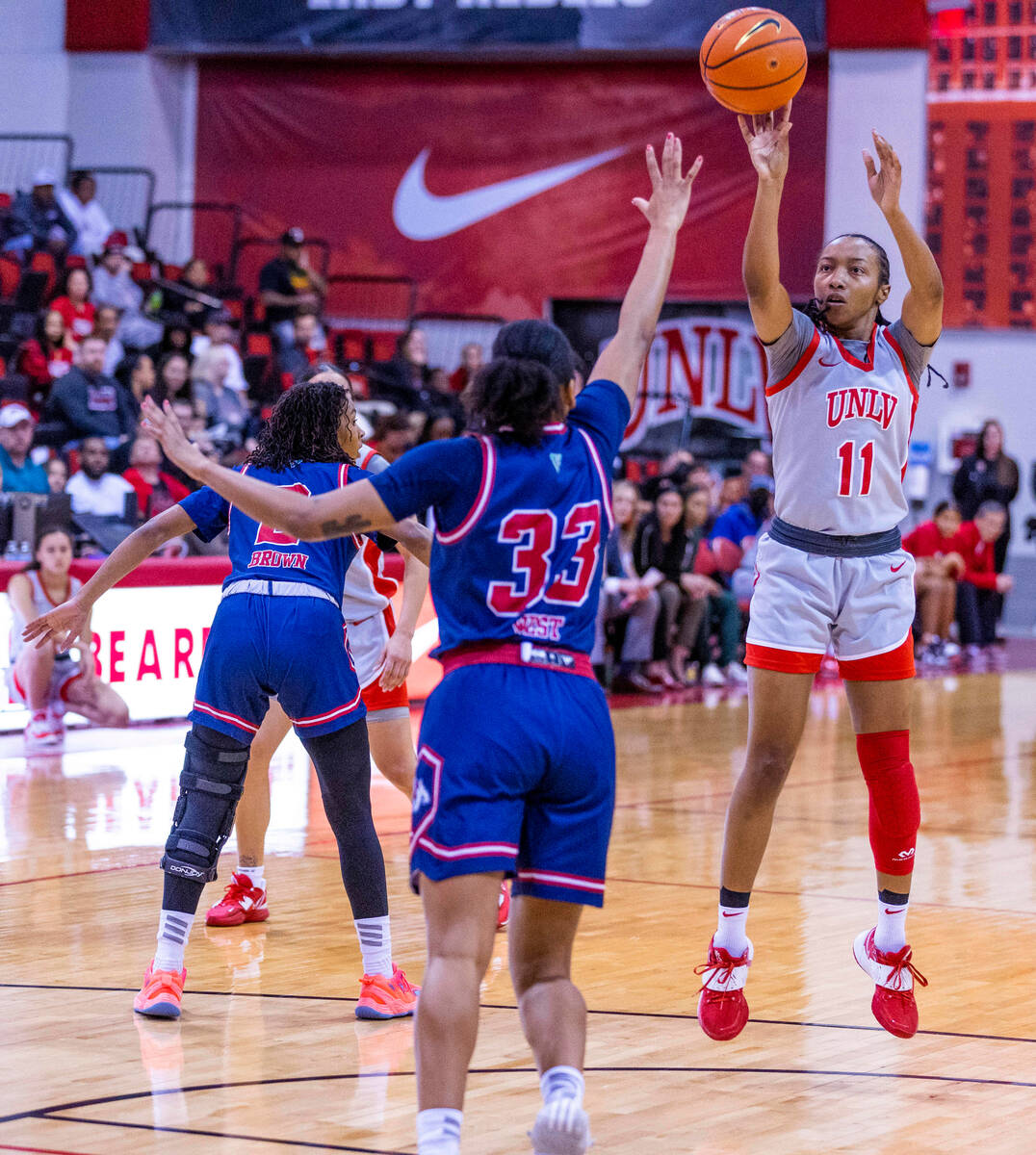 UNLV Lady Rebels guard Justice Ethridge (11) lets go a jump shot over Fresno State Bulldogs gua ...