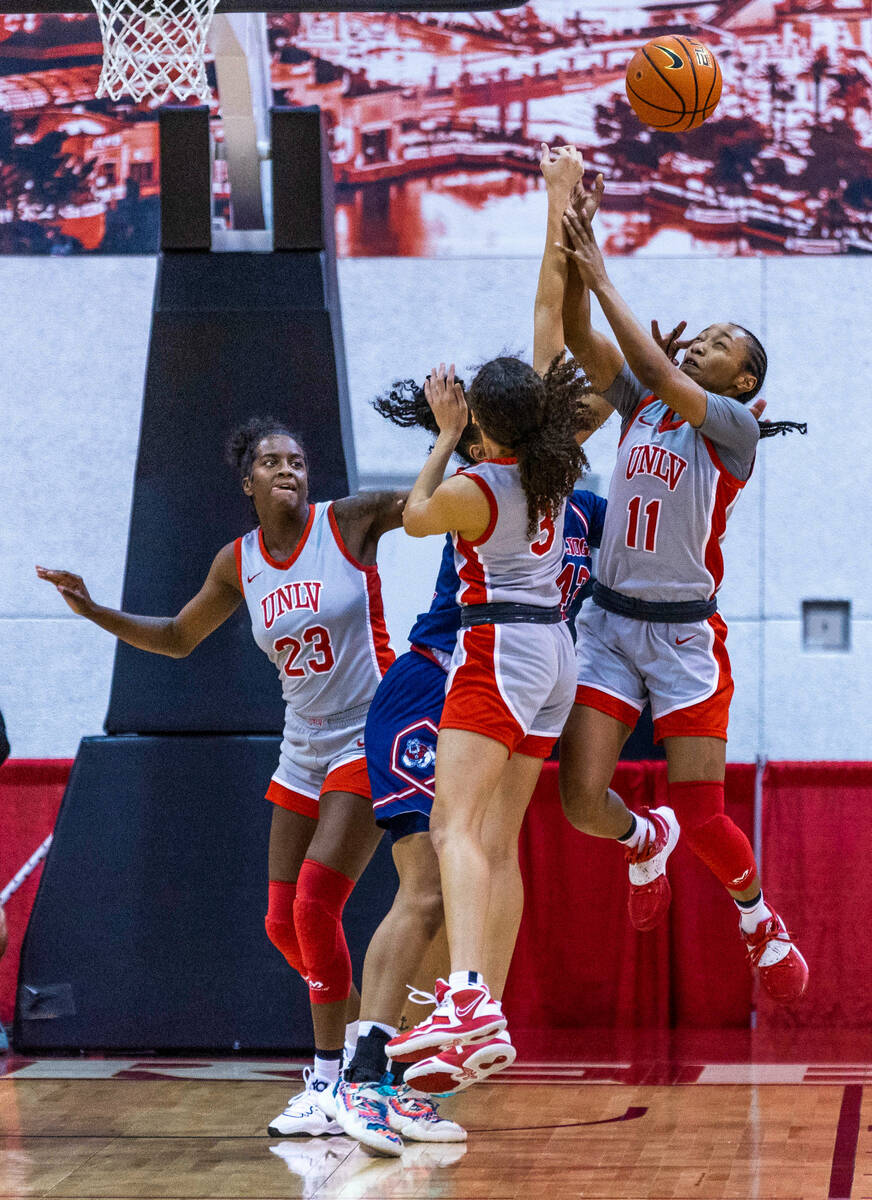 UNLV Lady Rebels guard Justice Ethridge (11) and guard Kiara Jackson (3) team up to deflect the ...