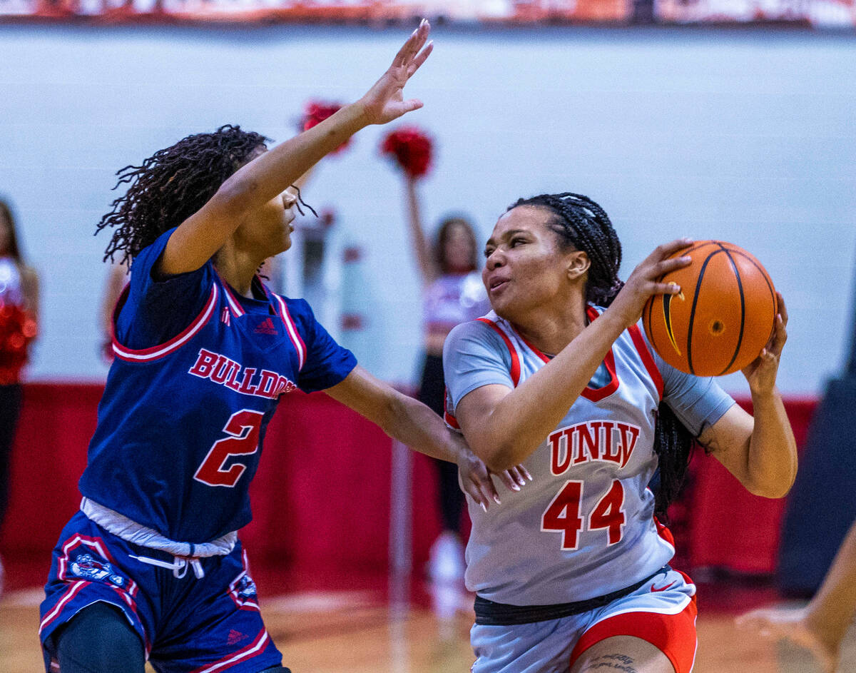 UNLV Lady Rebels forward Alyssa Brown (44) looks to pass around Fresno State Bulldogs guard Kee ...