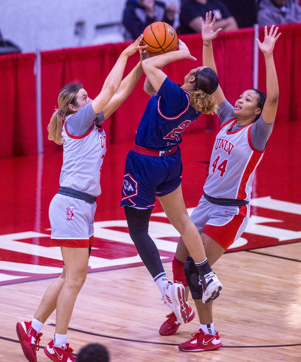 UNLV Lady Rebels guard Kenadee Winfrey (2) rejects a shot by Fresno State Bulldogs forward Iman ...