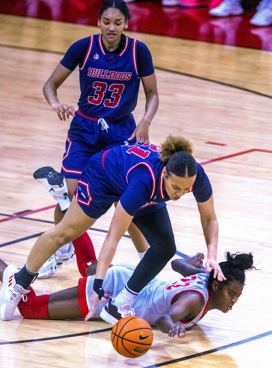 UNLV Lady Rebels center Desi-Rae Young (23) reaches for a loose ball with Fresno State Bulldogs ...