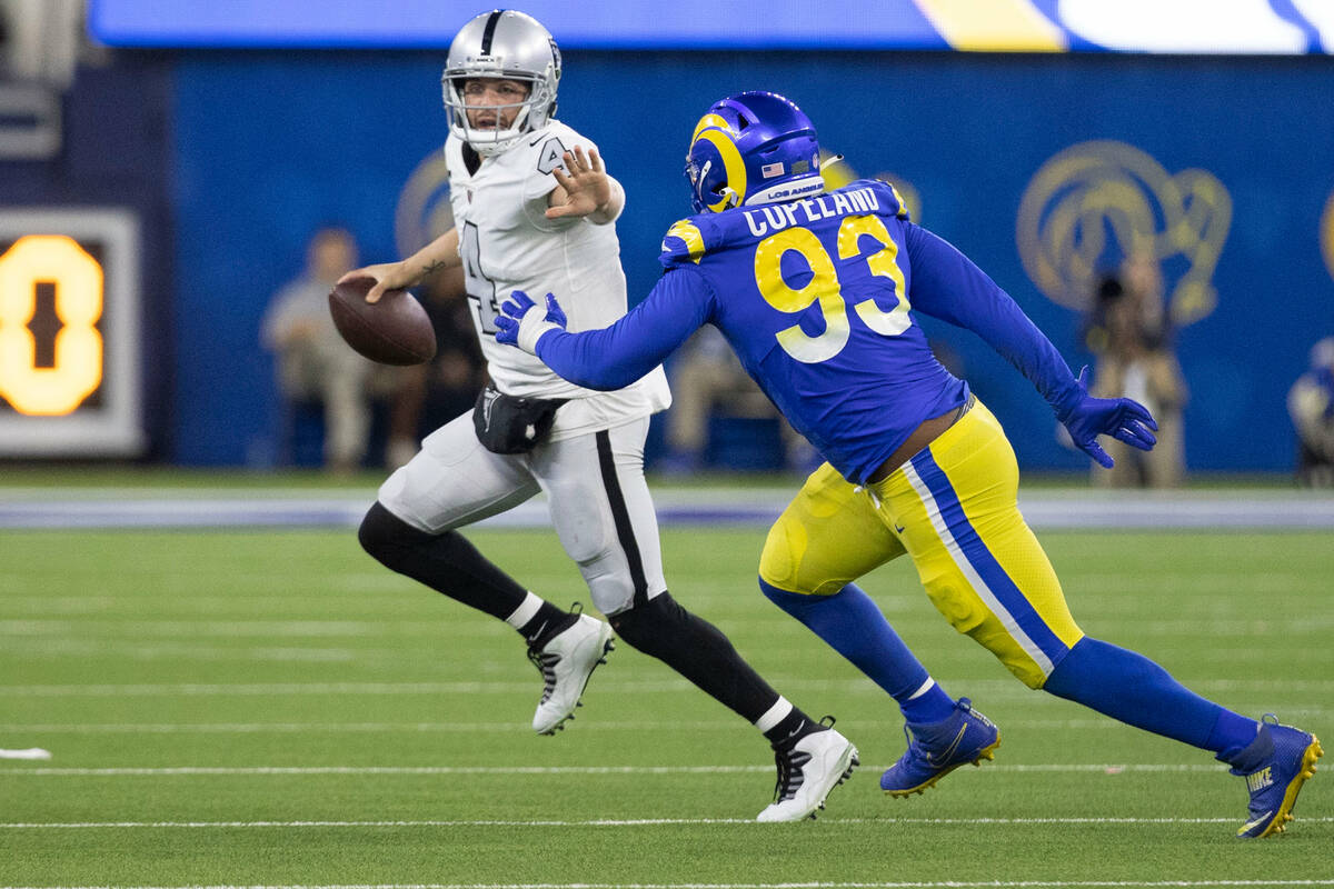 Raiders quarterback Derek Carr (4) scrambles under pressure from Los Angeles Rams defensive tac ...