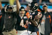 Chicago Bears coach Lovie Smith, back left, holds his hands in the air as Devin Hester (23) ret ...