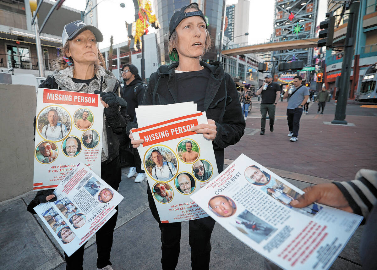 Jennifer Best of Las Vegas, center, and her sister Michele Mullins of Chicago hand out missing ...
