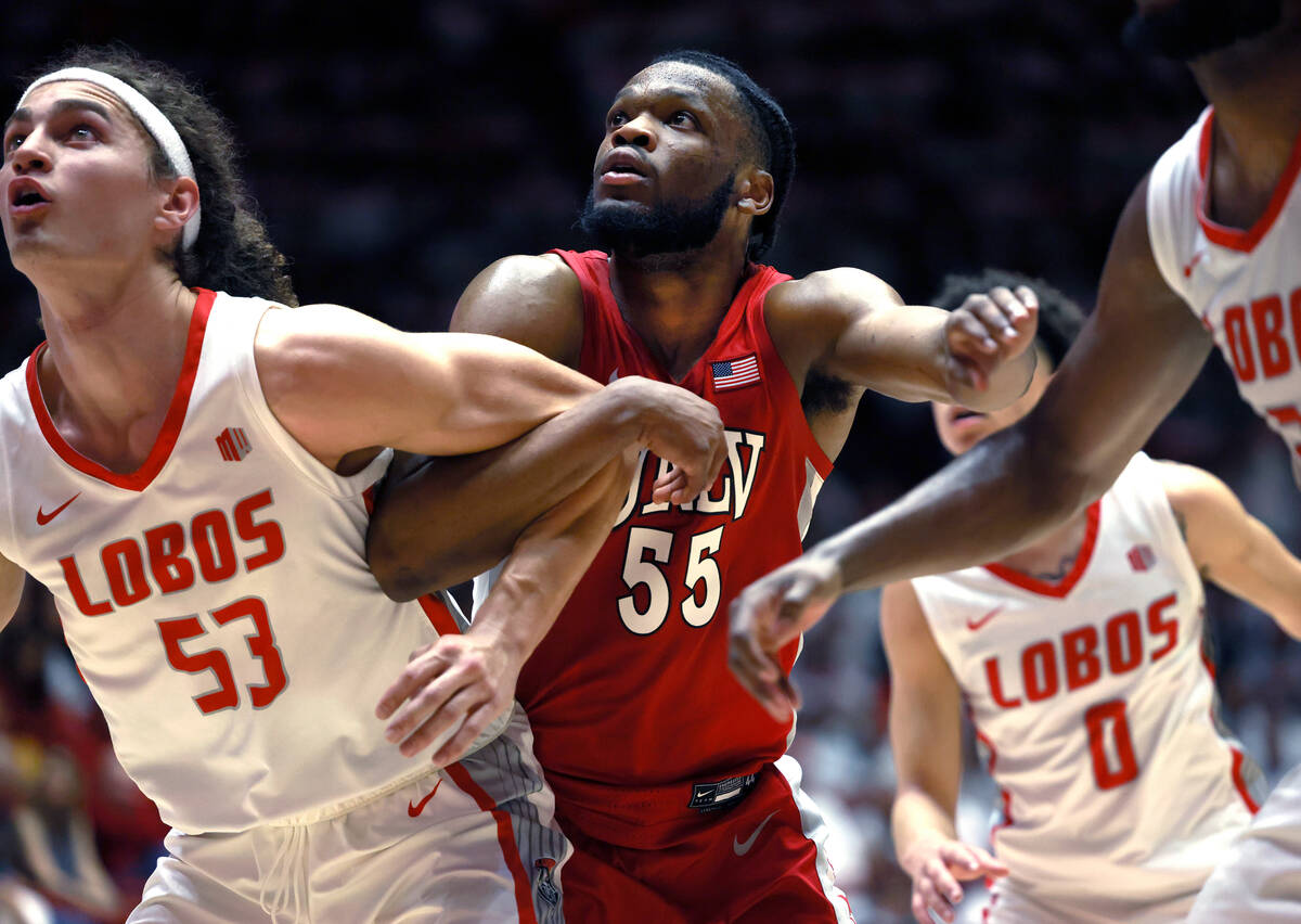 UNLV's Elijah Harkless, center, and New Mexico's Josiah Allick, wait for a rebound during the s ...